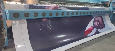 A wide-format press running a printed panel